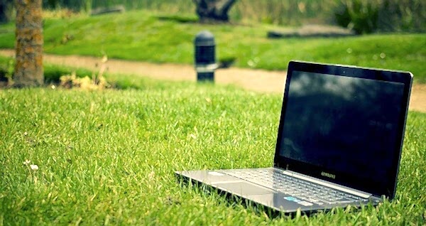 Laptop laid on grass